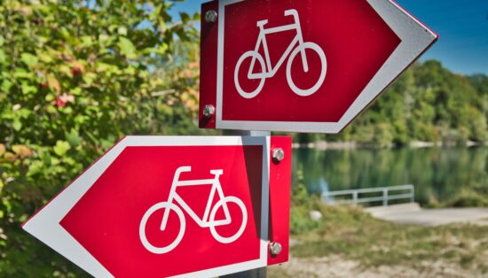 Photo de deux panneaux de pistes cyclables indiquant des directions opposées