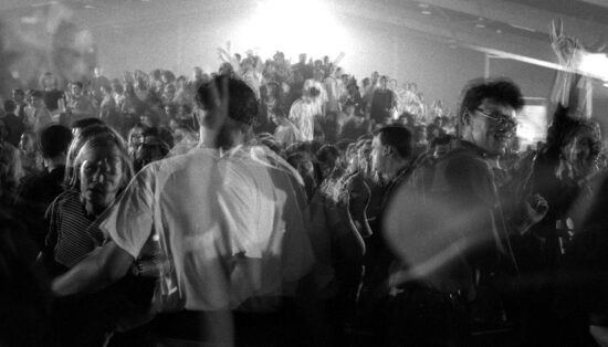 Photo noir et blanc floue avec des doubles expositions représentant un public de concert en train de danser